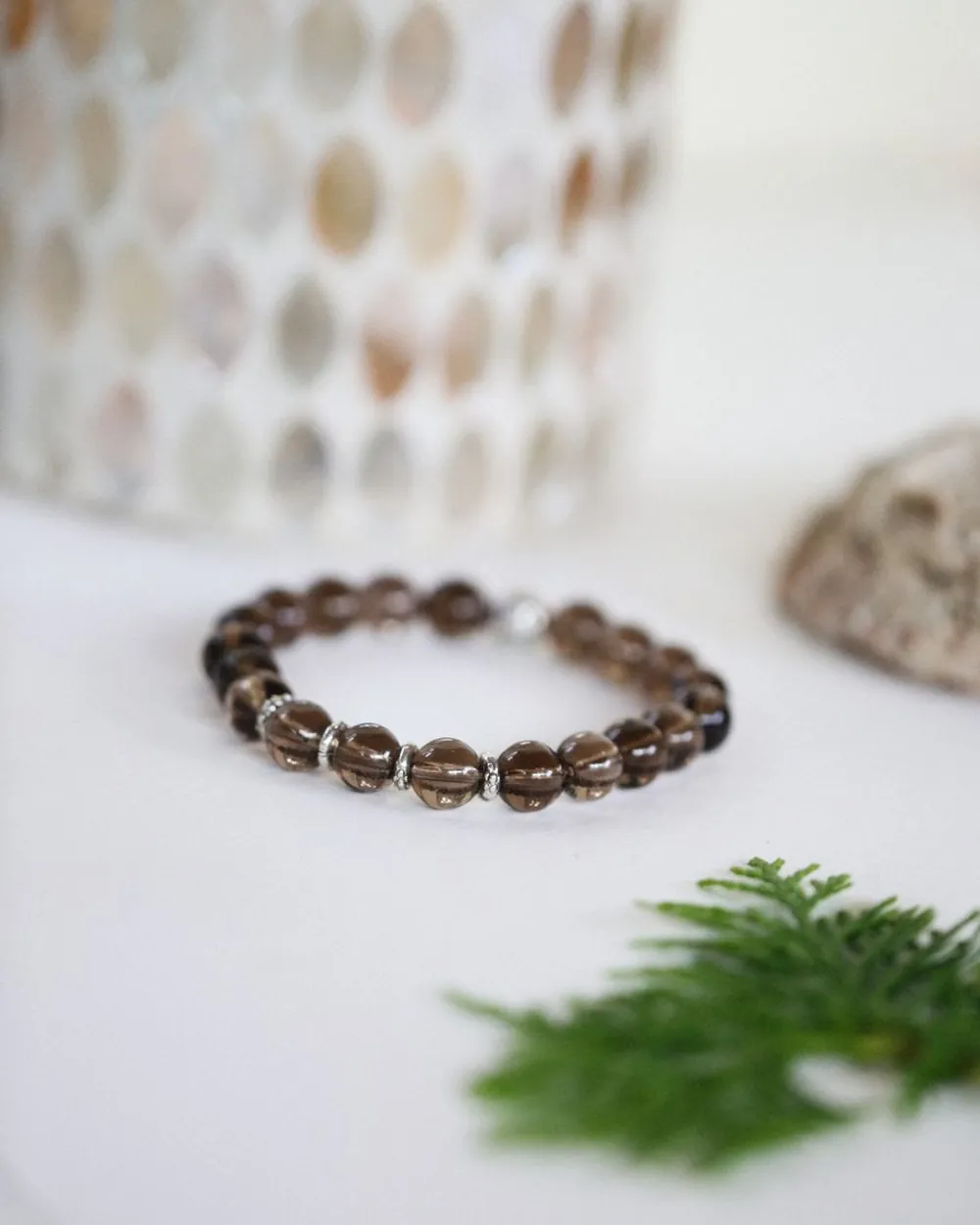 Bracelet de perles fumées posé sur une table claire