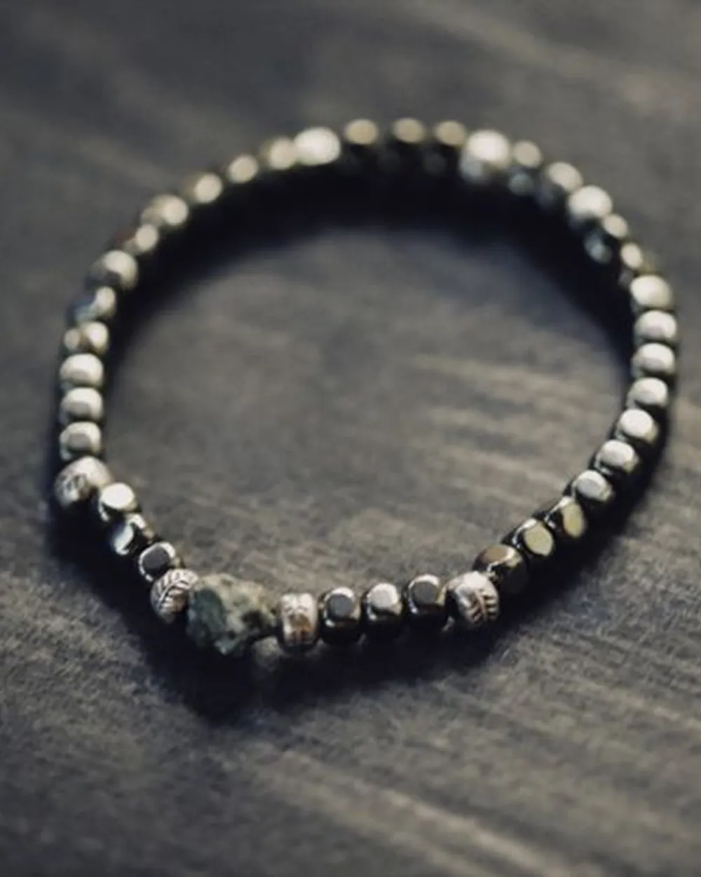 Bracelet de perles sombres sur une surface texturée