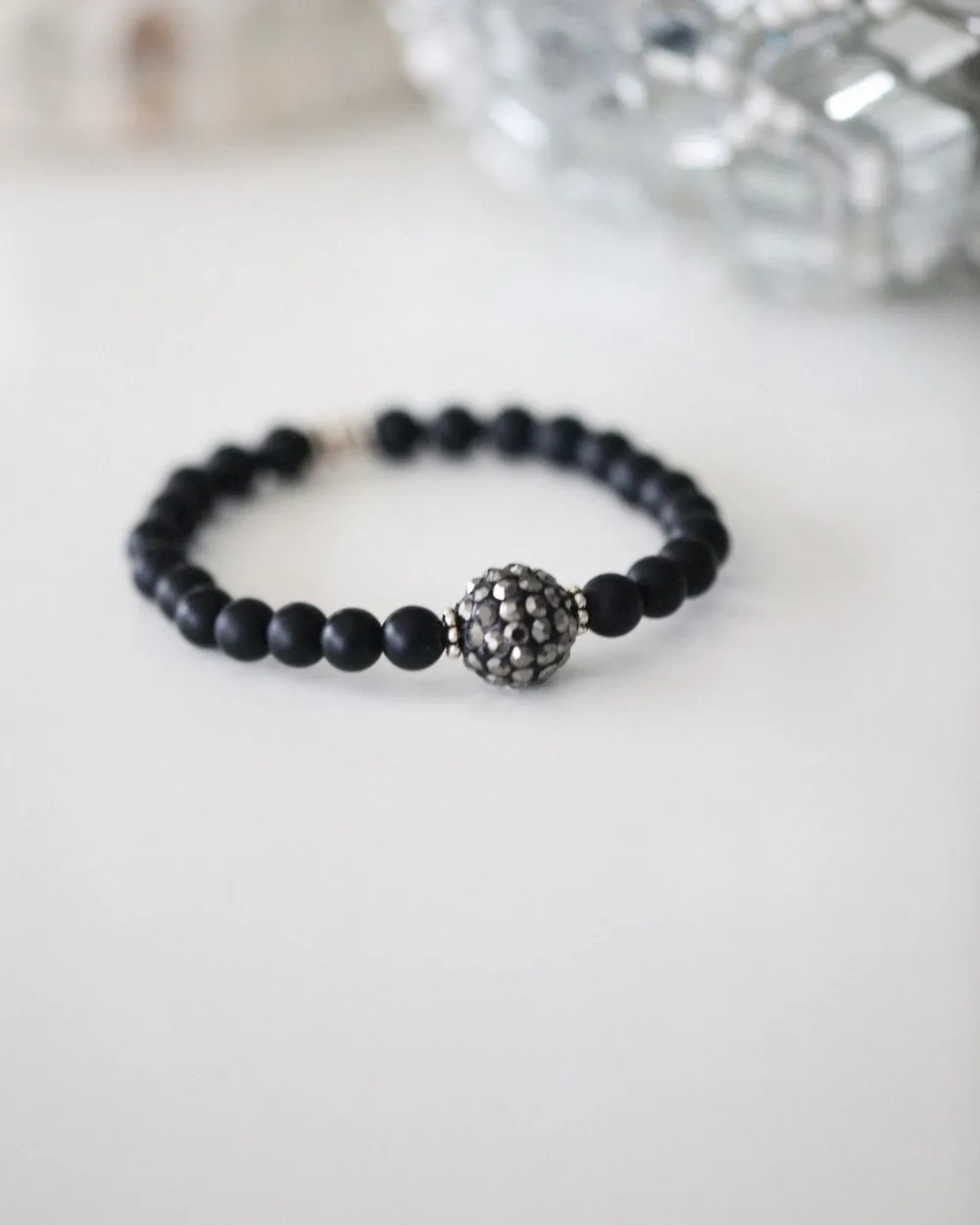 Bracelet de perles noires avec une perle ciselée