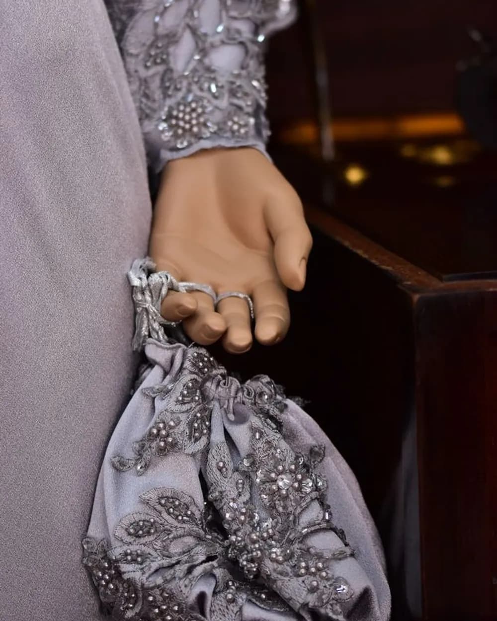Petite aumônière perlée tenue à la main