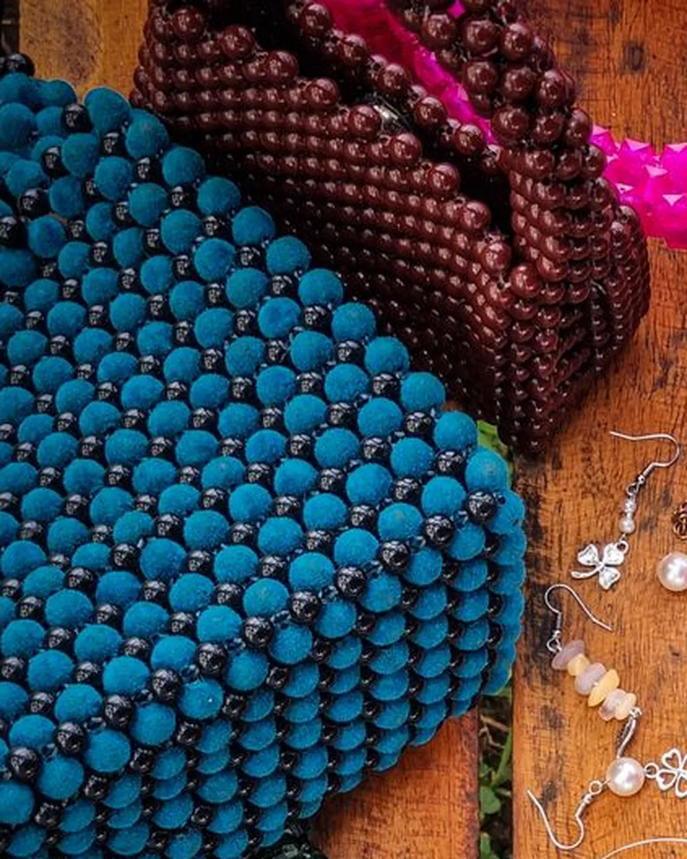 Sac tissé de grosses perles rondes, posé sur du bois