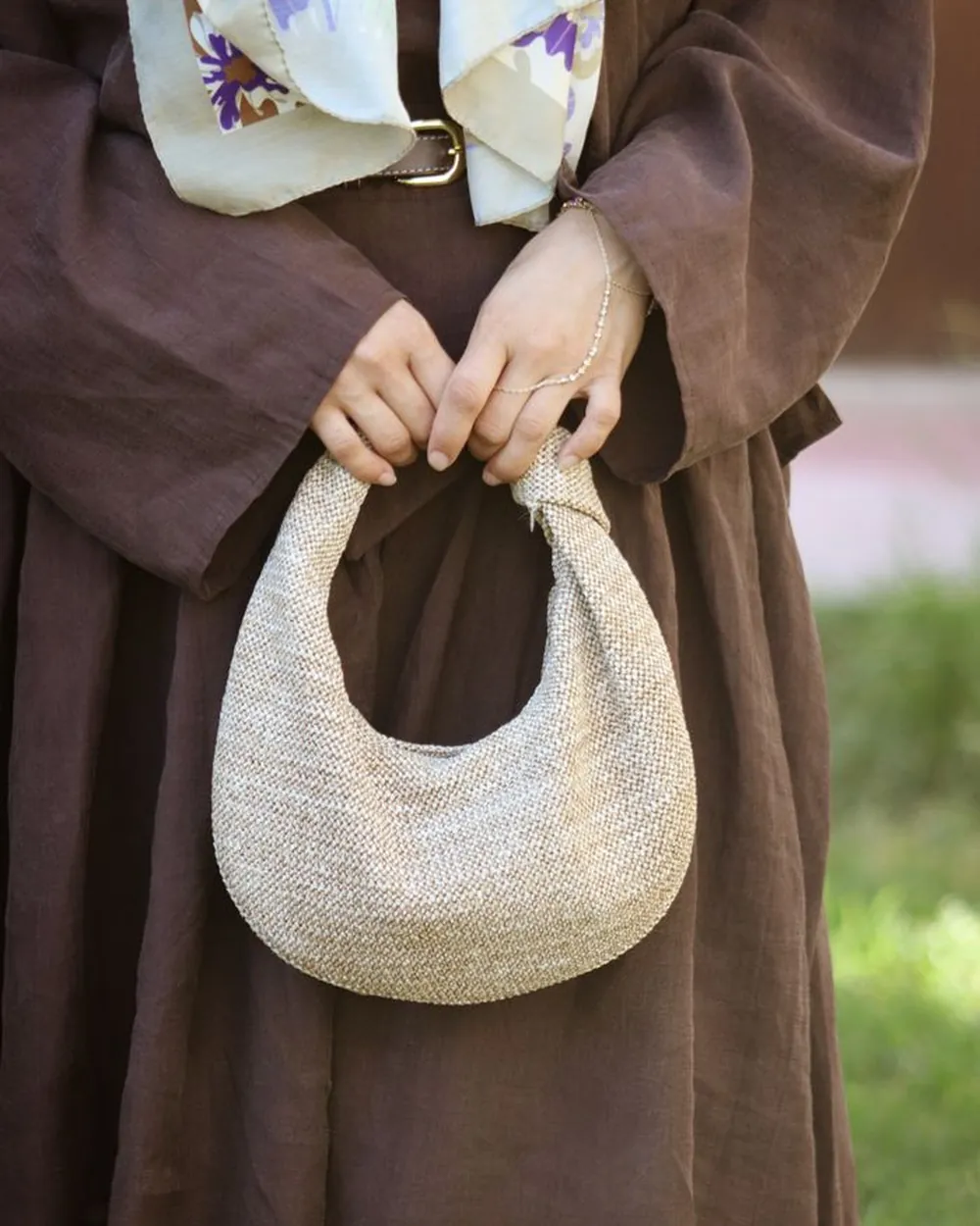 Sac demi-lune perlé tenu à deux mains